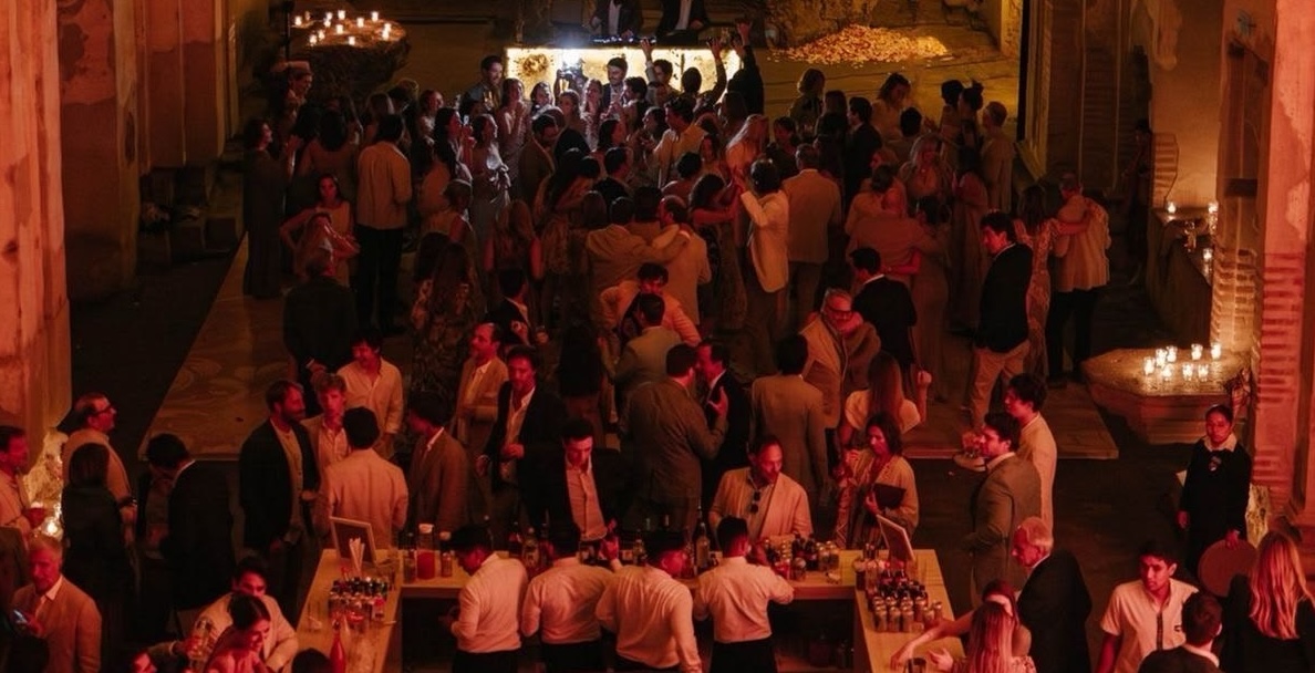 Guests gathered at a corporate event in a warm, atmospheric setting.