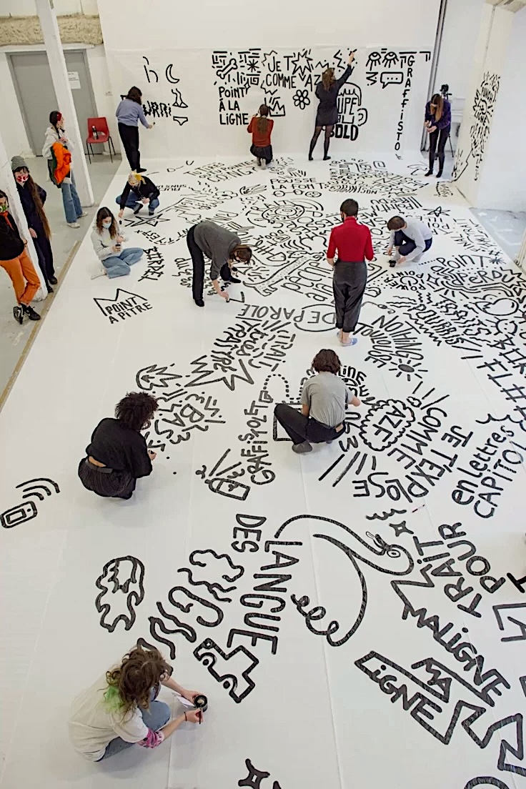 Participants creating a large-scale graphic artwork together