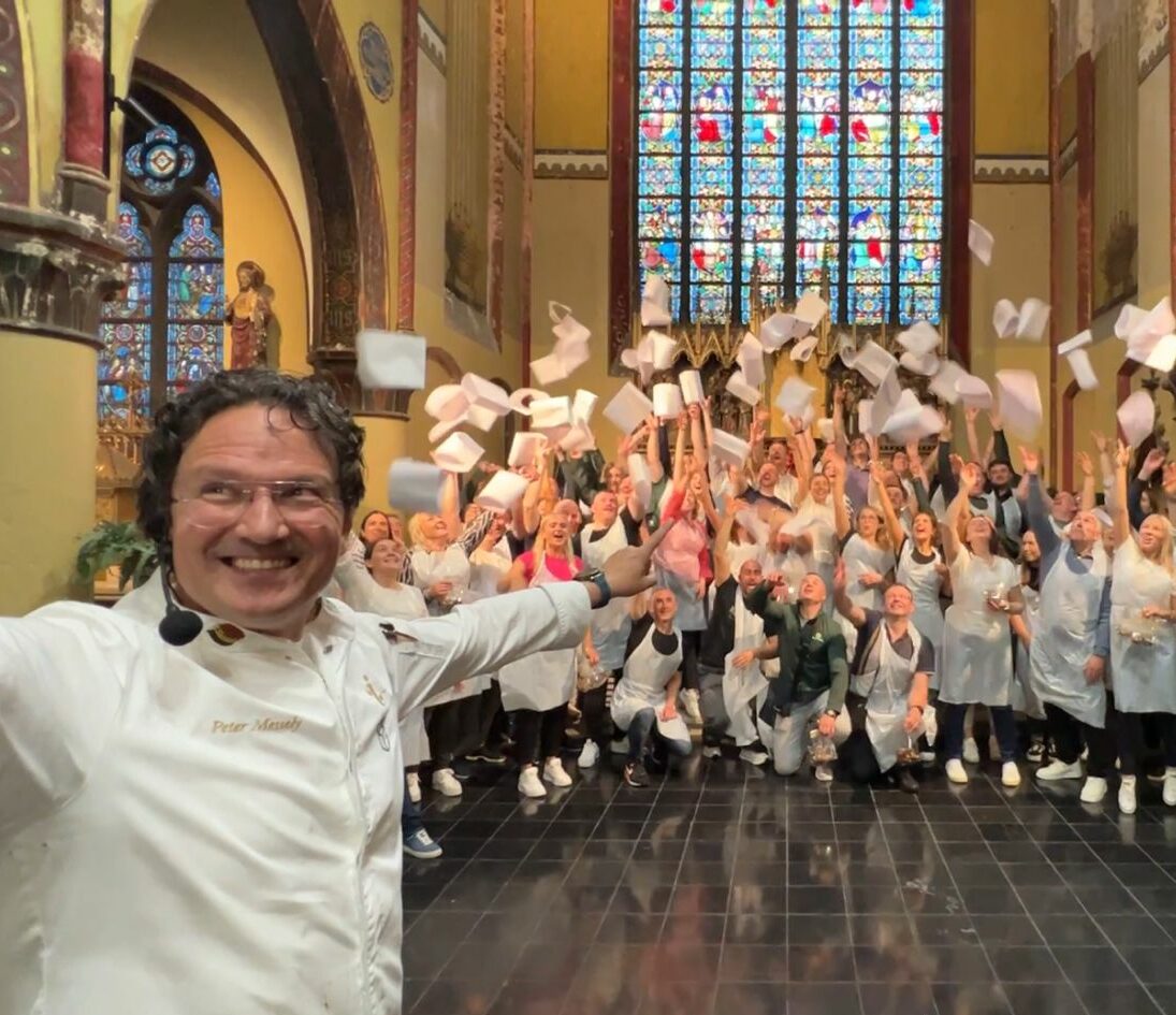 A large group celebrates the end of a creative chocolate workshop.